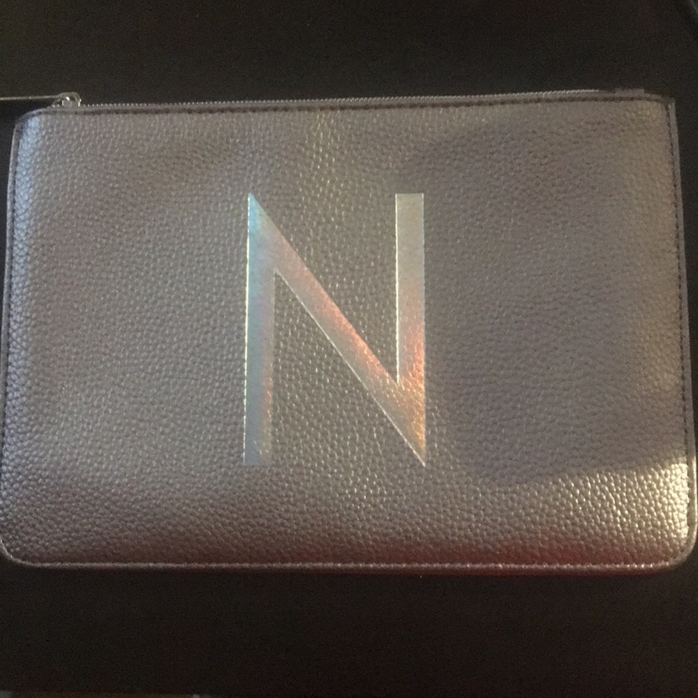 Silver makeup bag with an holographic N